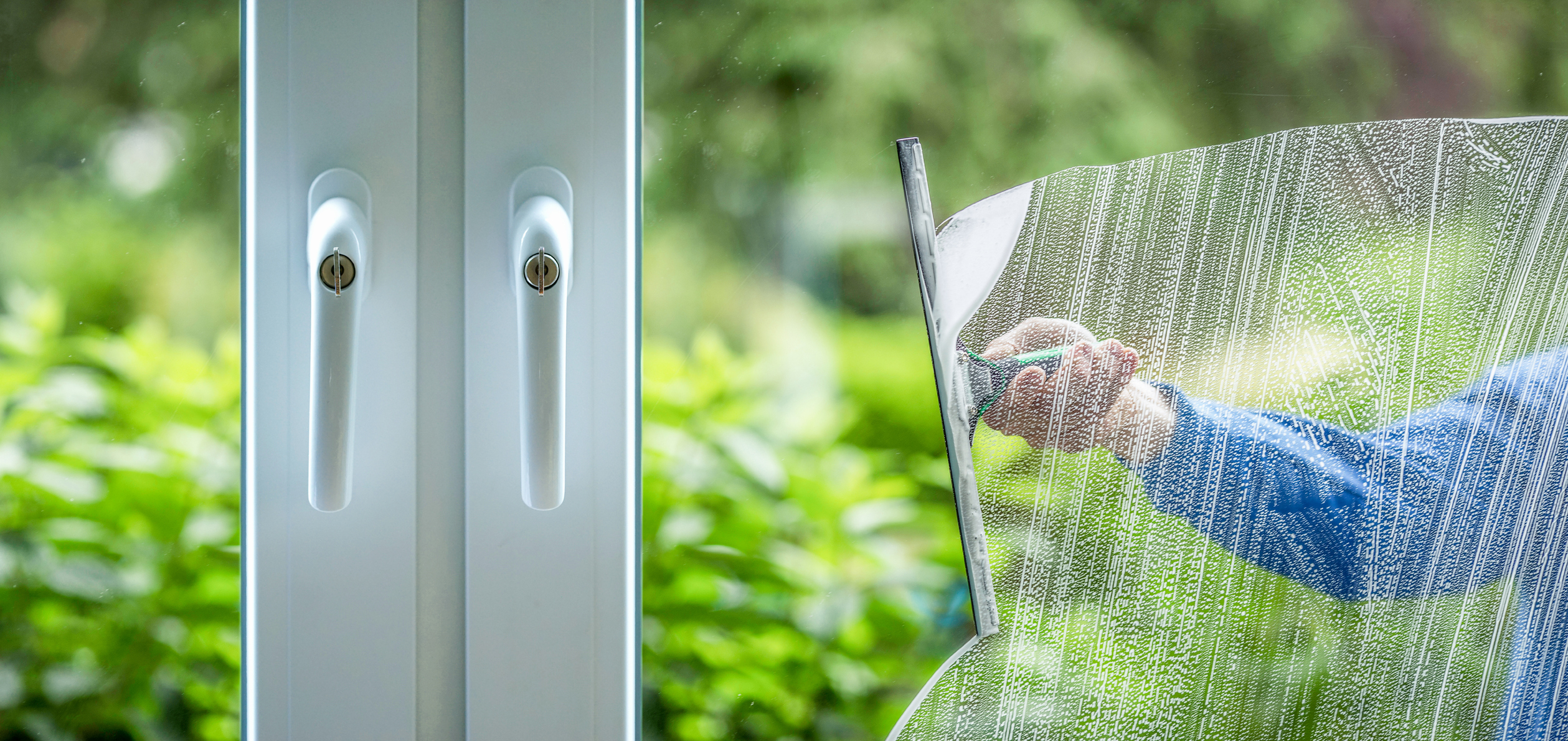 Glass cleaning squeegee on a window with detergent in Burlington, VT